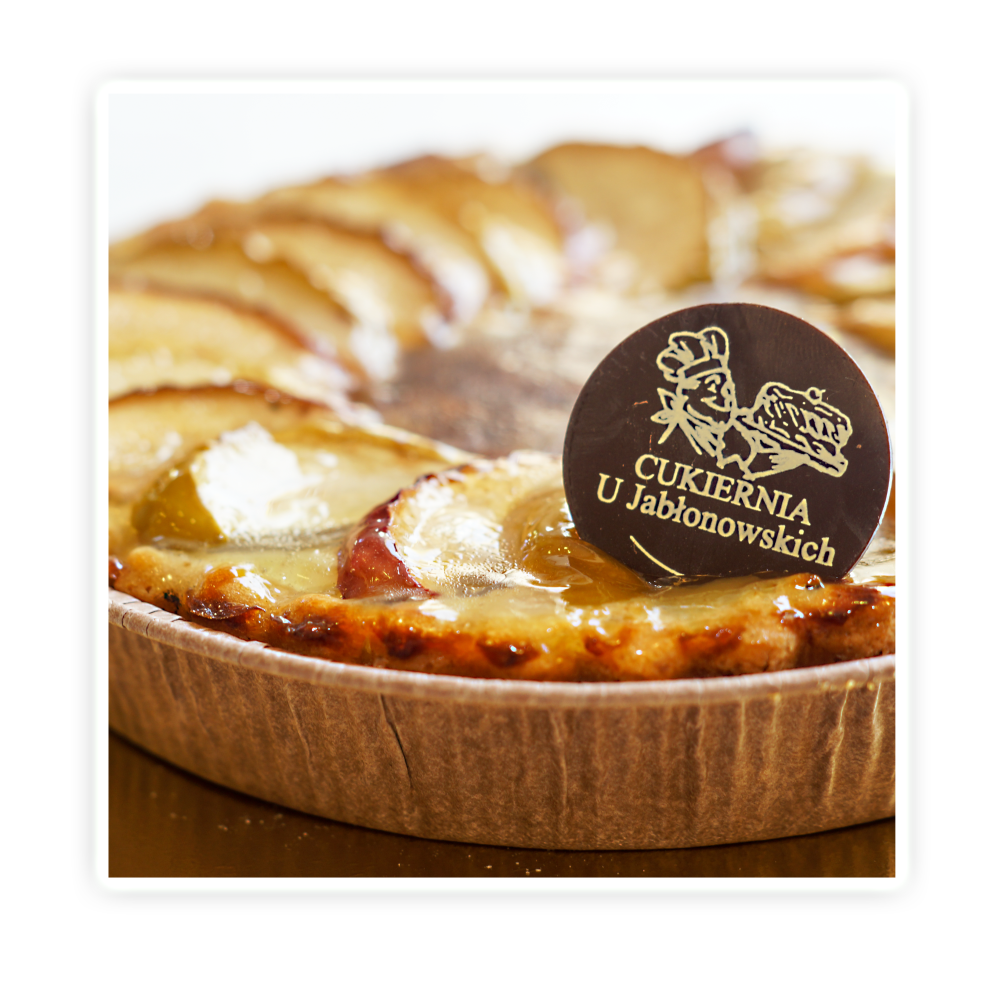 Tarta jabłkowa - Delikatne kruche ciasto wypełnione masą jabłkową, wykończone jabłkami.